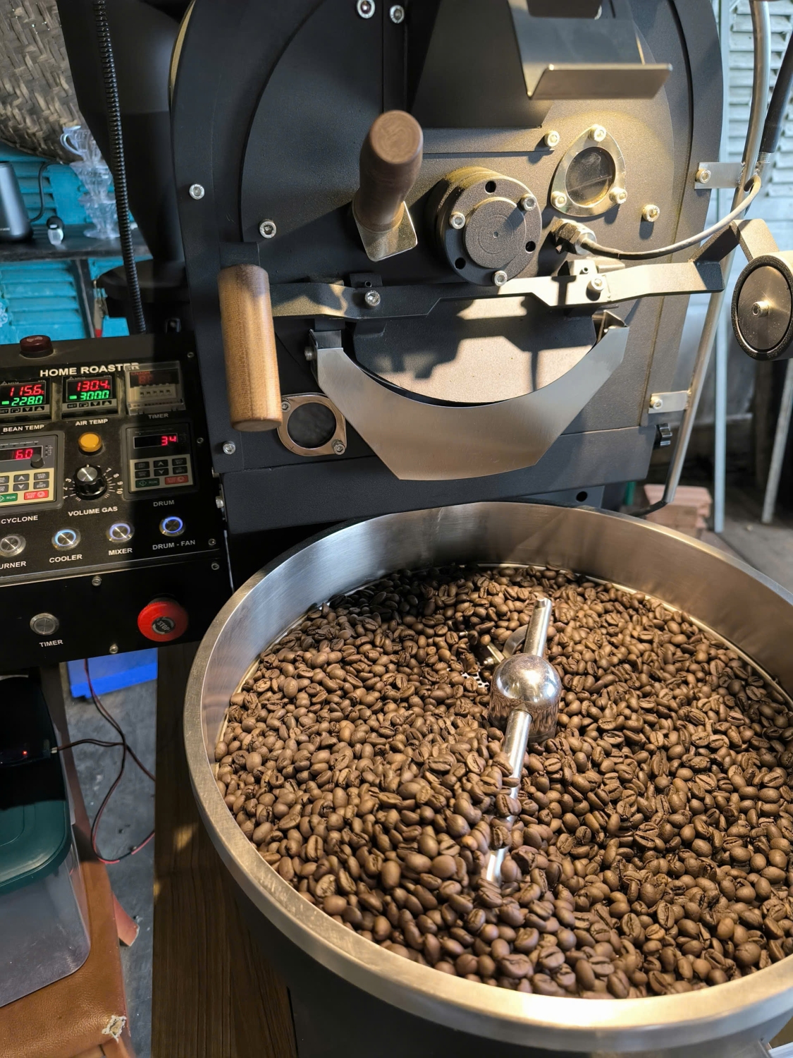 Dark‑roasted Robusta coffee beans at HuyEco Coffee & Culture, expanded in size and rich in color, resting in cooling mode after roasting.